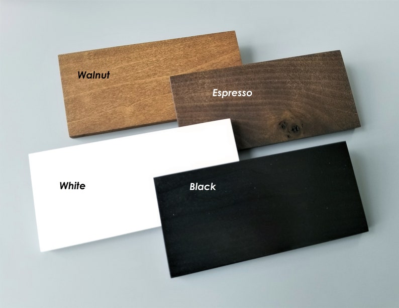 May include: Four wood samples in different colors: walnut, espresso, white, and black. The samples are arranged in a staggered pattern.