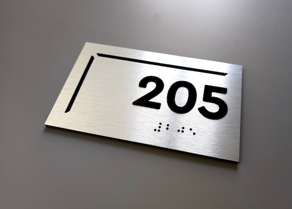 ADA compliant custom number plaques. Modern ADA hotel room number signs. Apartment number signs with Braille. Tactile door numbers.