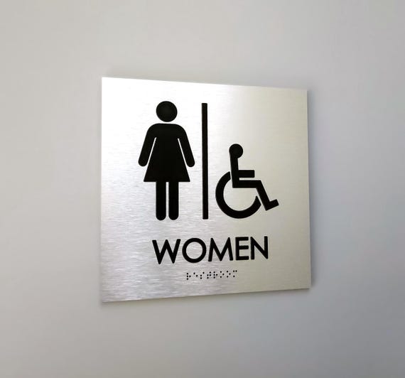 Accessible women restroom sign. Handicap accessible women's bathroom. ADA compliant bathroom signs. Tactile Braille signs.