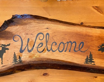 Hand painted welcome sign with two moose.