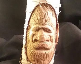 Hand carved tree spirit on a birch branch.