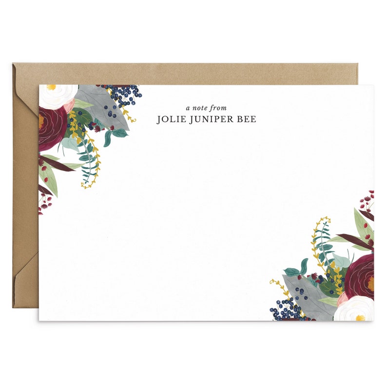May include: A white card with a floral design in shades of burgundy, blue, and green. The text "a note from JOLIE JUNIPER BEE" is printed in black at the top of the card.