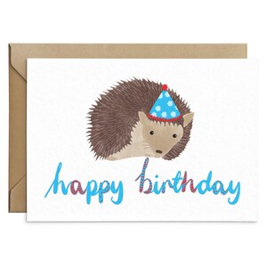 May include: A birthday card featuring a cartoon hedgehog wearing a blue and white party hat. The card has the text "happy birthday" in blue with red and white accents.
