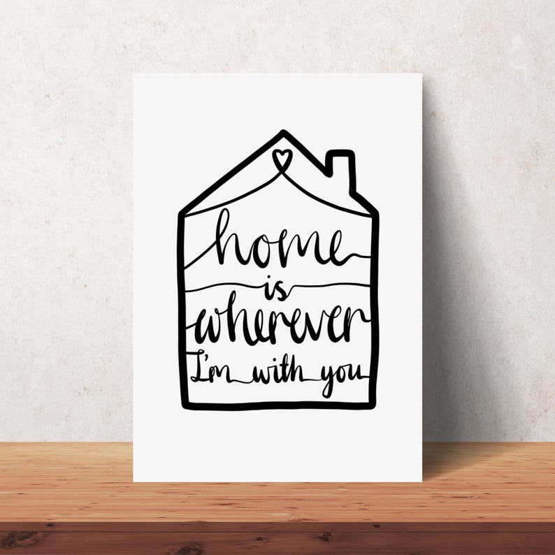May include: A white rectangular print with a black outline of a house. The words "home is wherever I'm with you" are written in a handwritten style inside the house outline. A heart is at the top.
