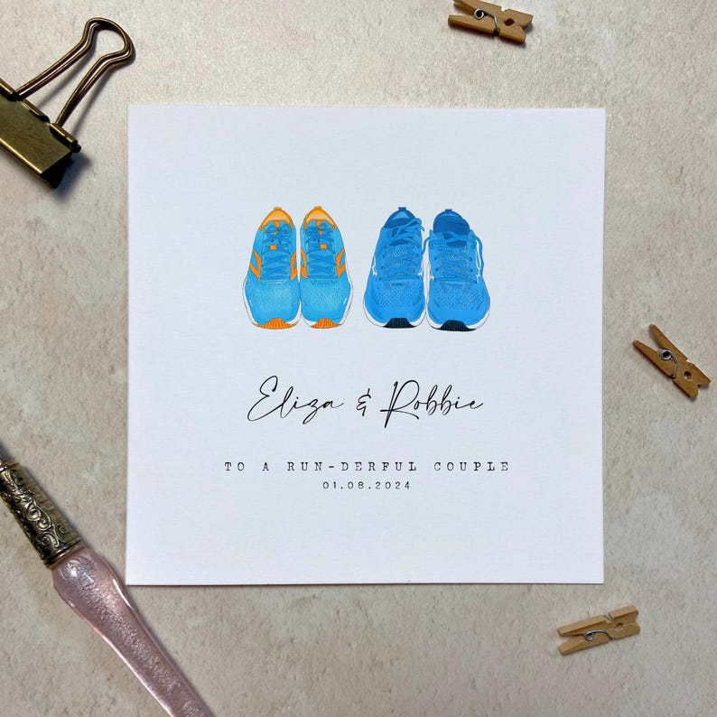 May include: A white card with a blue and orange illustration of two pairs of running shoes. The text "Eliza & Robbie" is written in cursive. The text "To a run-derful couple 01.08.2024" is printed below the illustration.