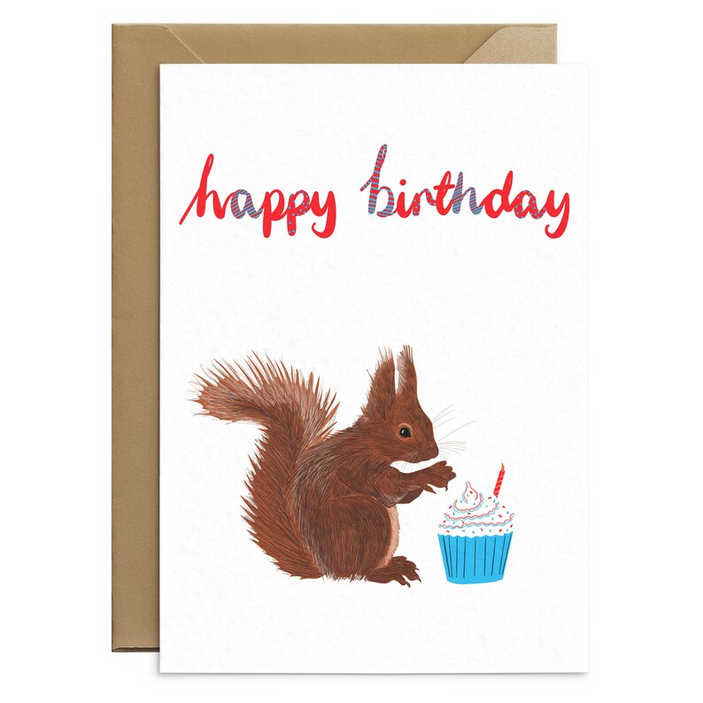 May include: A red squirrel with a bushy tail looks at a blue cupcake with white frosting and a red candle. The card says "happy birthday" in red and blue lettering.