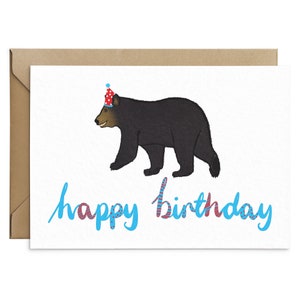 May include: A birthday card with a black bear wearing a red and white party hat. The text "happy birthday" is written in blue with red and white accents.