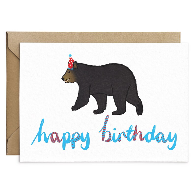 May include: A birthday card with a black bear wearing a red and white party hat. The text "happy birthday" is written in blue with red and white accents.