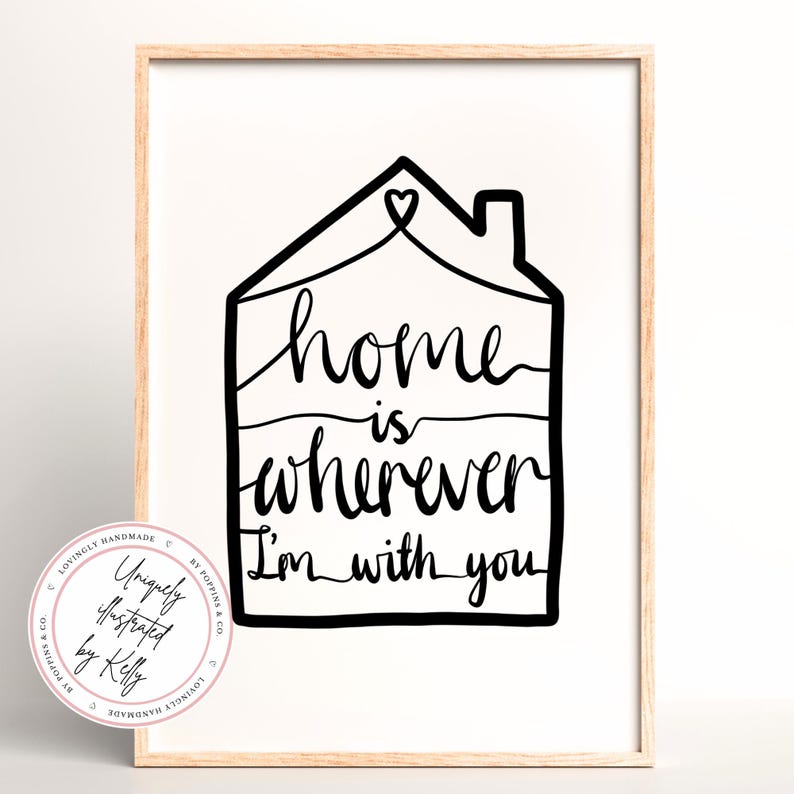 May include: A framed art print with a minimalist design. The black line art features a house outline with the words "home is wherever I'm with you" in a handwritten style. A circular logo is in the lower left corner.