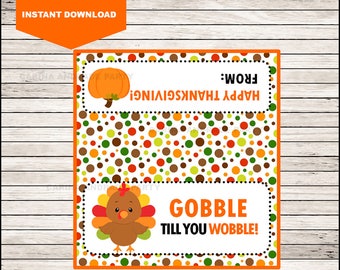 May include: A rectangular printable tag featuring a pattern of orange, green, and brown polka dots. The top section displays an orange pumpkin and the text HAPPY THANKSGIVING FROM. The bottom section shows a cartoon turkey and the text GOBBLE TILL YOU WOBBLE.