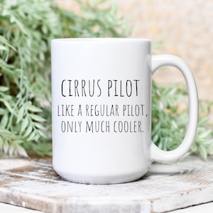 May include: White ceramic coffee mug with black text that reads "Cirrus Pilot Like a regular pilot, only much cooler."