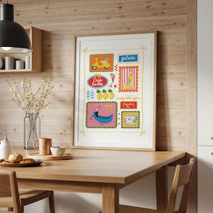 May include: A framed print with Italian-themed illustrations, including a yellow scooter, gelato, and a gondola. The artwork also features the phrases "Ciao Bella" and "Aperitivo Bar." The print is in a light wood frame and displayed on a wooden table.