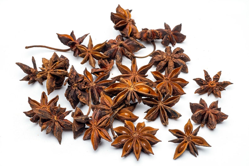 May include: A collection of dried star anise pods, a popular spice used in Asian cuisine. The pods are brown and have a star shape with eight points.