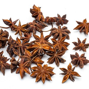 May include: A collection of dried star anise pods, a popular spice used in Asian cuisine, scattered on a white background.