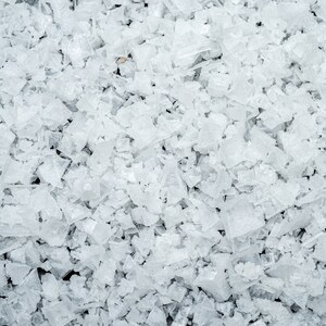 May include: Close-up of a pile of white, translucent, irregularly shaped salt crystals.