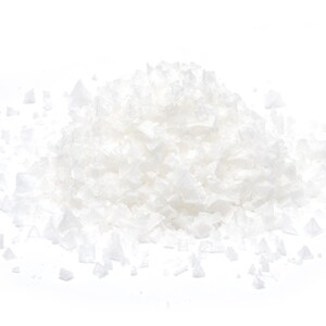 May include: A pile of white sea salt crystals on a white background.
