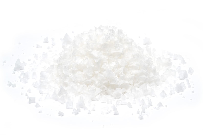 May include: A pile of white sea salt crystals on a white background.