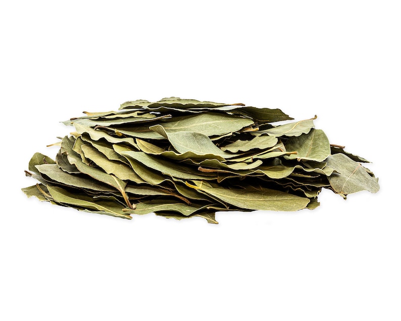 May include: A pile of dried bay leaves, a common culinary herb, arranged in a loose mound on a white background.