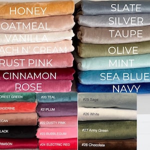 May include: A collection of folded fabric swatches in various colors labeled with text including Honey, Oatmeal, Vanilla, Peach N' Cream, Rust Pink, Cinnamon, Rose, Slate, Silver, Taupe, Olive, Mint, Sea Blue, Navy, Forest Green, Teal, Plum, Dusty Pink, Bubblegum, Electric Red, Crimson, Black, Pecan, Tangerine, Sage, White, Army Green, and Chocolate.