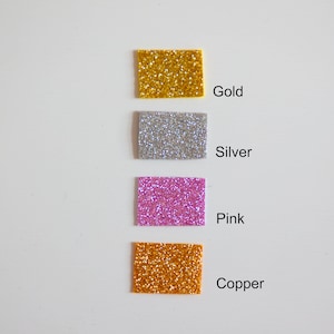 May include: Four square samples of glitter in gold, silver, pink, and copper.