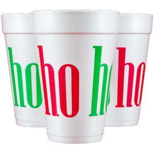 May include: Three white foam cups arranged in a cluster. Each cup features the text hoho ho printed in alternating red and green letters. The cups have a textured surface and a tapered cylindrical shape with a wide rim at the top and a narrow base.