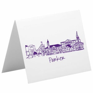 May include: Purple line drawing of a city skyline with the word "Parker" written below. The skyline includes buildings, a church, and a stadium.
