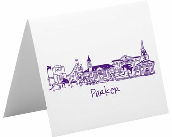 May include: Purple line drawing of a city skyline with the word "Parker" written below. The skyline includes buildings, a church, and a stadium.