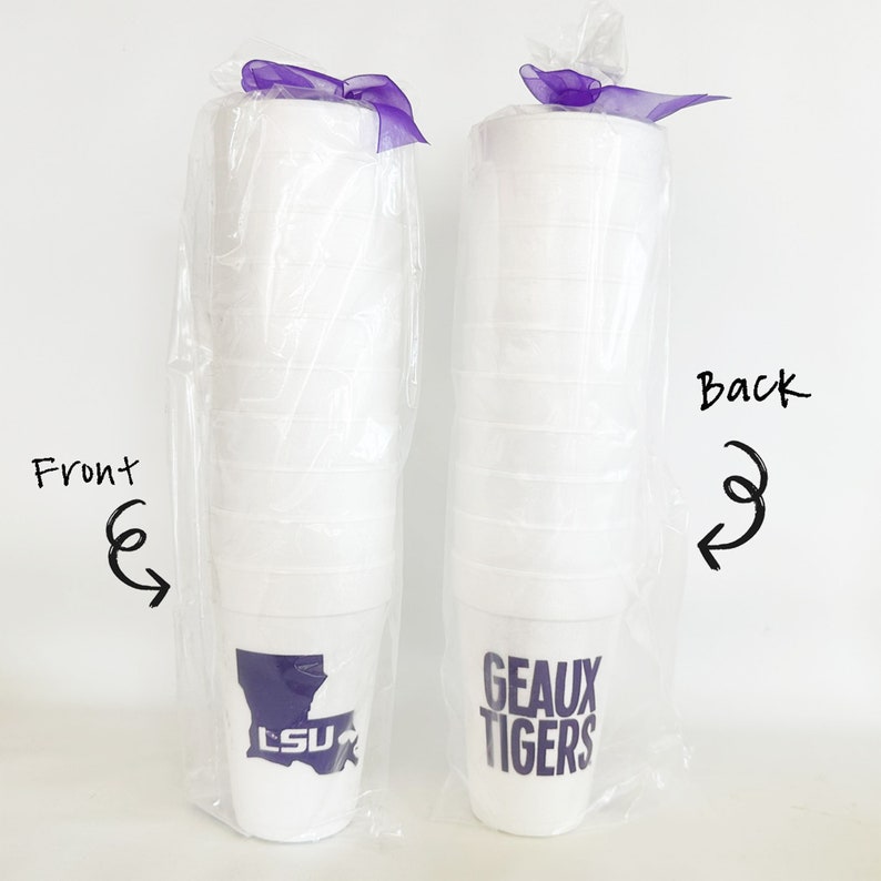 May include: Two stacks of white foam cups, each wrapped in clear plastic and tied with a purple ribbon. One stack features a purple Louisiana state outline with "LSU" inside. The other says "GEAUX TIGERS" in purple.