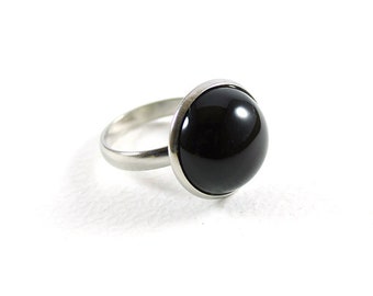 Op de afbeelding: Een zilveren ring met een ronde zwarte edelsteen.