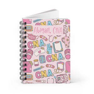 May include: A pink spiral notebook with a colorful pattern of medical symbols and the text "Abigail, CNA".
