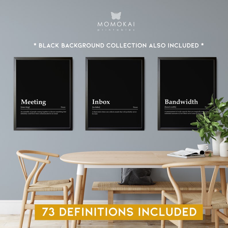 May include: Three black framed prints with white text on a black background. The prints are titled "Meeting", "Inbox", and "Bandwidth" and include definitions for each word. The prints are hanging on a light gray wall above a wooden table and chairs. The text "73 DEFINITIONS INCLUDED" is displayed below the prints.