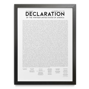 May include: A framed print of the Declaration of Independence. The text is in black on a white background, with the title "Declaration of the Thirteen United States of America" at the top. The frame is black.