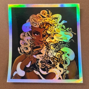 May include: Holographic sticker featuring a woman with snakes for hair, in a Medusa-inspired design. The snakes are various colors, including yellow, green, and white, against a dark background. The sticker has a shiny, iridescent border.