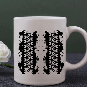 May include: White ceramic mug with a black tire tread print design. The print is of two tire treads with a splatter effect.