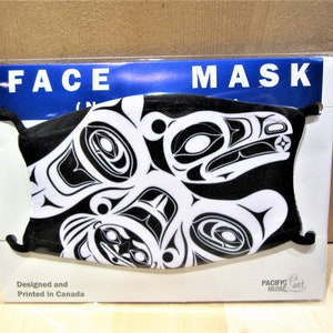 May include: Black and white face mask with a stylized design of a creature with a beak and eyes. The mask is packaged in a clear plastic bag with a white card that says "FACE MASK" in blue letters. The card also says "Designed and Printed in Canada" and "PACIFIC MUSIC ART".