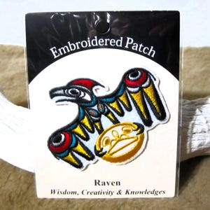 以下が含まれることがあります： 「Embroidered Patch」と「Raven, Wisdom, Creativity & Knowledges」の文字が書かれた、カラフルなカラスのデザインが刺繍されたパッチです。