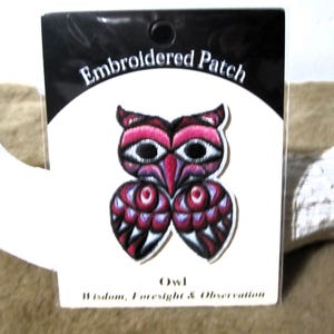 Può includere: Toppa ricamata con un design a gufo stilizzato, principalmente rosa e viola, con dettagli neri e bianchi. La toppa è su uno sfondo bianco con le parole "Embroidered Patch" e "Owl" stampate.