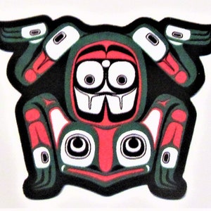 May include: A stylized red, green, white, and black frog with large eyes and a wide mouth. The frog is depicted in a traditional Northwest Coast Native American art style.