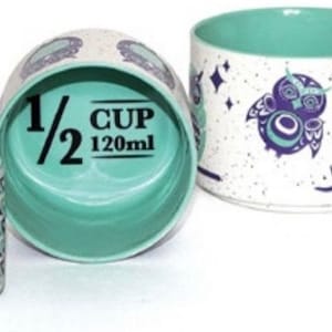 Può includere: Set di quattro tazze da misurazione in ceramica con un design a forma di gufo. Le tazze sono bianche con un motivo a gufo turchese e viola. Le tazze misurano 1/4 di tazza, 1/3 di tazza, 1/2 di tazza e 1 tazza.