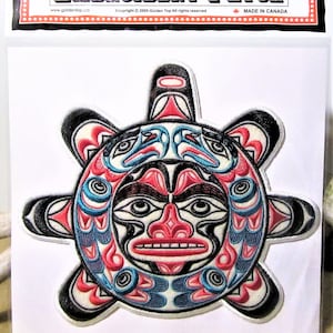 Può includere: Toppa ricamata con un viso stilizzato del sole in uno schema di colori nero, rosso, blu e bianco. Il viso del sole è circondato da un design circolare con un motivo a stella. La toppa è realizzata in Canada.