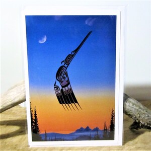 May include: A greeting card featuring a stylized black and purple bird with a long beak flying against a blue and orange sunset sky. The bird is in a traditional Native American art style.