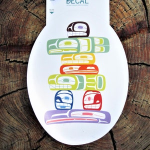 Op de afbeelding: Een kleurrijke, herbruikbare sticker met een gestileerde totempaal in bruin, groen, geel, oranje, blauw en paars. De sticker is op een witte achtergrond.