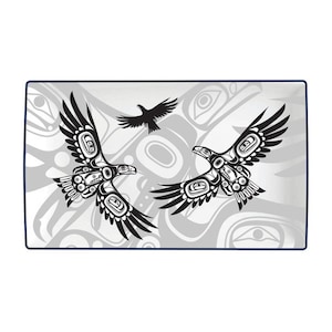 May include: A white ceramic tray with a blue border features a black and white stylised design of two eagles in flight. The eagles are depicted in a traditional Northwest Coast Indigenous art style. The background features a repeating pattern of stylised forms.