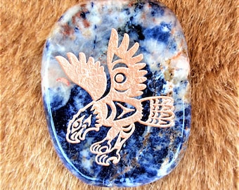 May include: A blue and white stone with a copper-colored eagle etched into it. The eagle is in flight with its wings spread wide. The stone is smooth and polished.