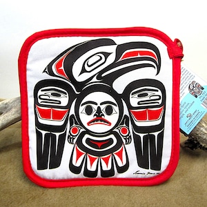 May include: Red and black pot holder with a white background featuring a stylized Native American eagle design. The text "Spirit Guides vision, strength, and wisdom" is printed on the tag attached to the pot holder.