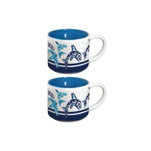 Könnte beinhalten: Set aus zwei weißen Keramikbechern mit blauen und türkisfarbenen, stilisierten Orca-Wal-Designs. Die Becher haben ein blaues Innenleben und einen blauen Streifen am Boden.