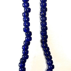 May include: A strand of dark blue glass beads, strung on a thin wire, with a simple clasp.