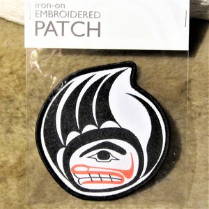 Può includere: Toppa ricamata da stirare con un designo stilizzato in bianco e nero di un viso con labbra rosse. La toppa è in una busta di plastica trasparente con il testo "iron-on EMBROIDERED PATCH" su un'etichetta bianca.