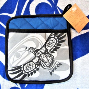 May include: Blue and grey quilted pot holder with a black border. The pot holder features a stylised black and white image of a soaring eagle with the text "Soaring Eagle" on the tag.