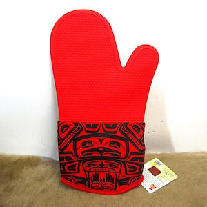 Può includere: Guanto da forno in silicone rosso con un design a motivi neri e rossi. Il motivo presenta un viso di animale stilizzato con forme geometriche.